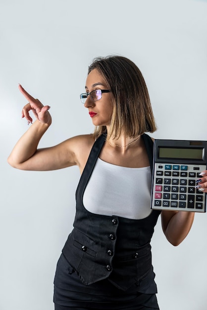 Foto atractiva chica nerviosa asustada sosteniendo calculadora mordiéndose las uñas aislado fondo de color azul