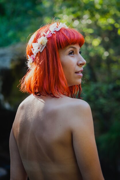 Atractiva chica de pelo rojo en la naturaleza.