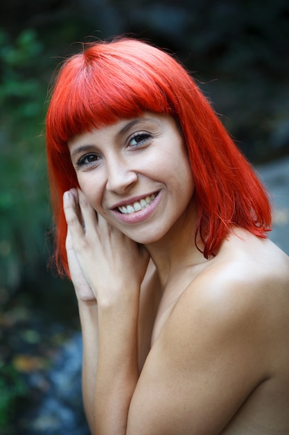 Atractiva chica de pelo rojo en la naturaleza.