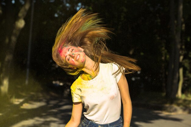 Atractiva chica rubia con viento en el cabello y colores vibrantes que explotan a su alrededor