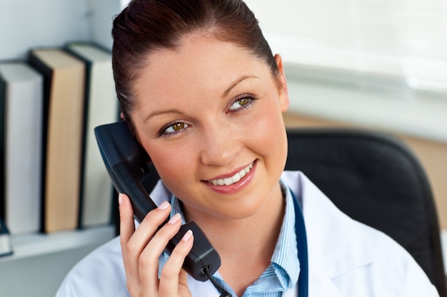 Foto atractiva doctora llamando en su oficina