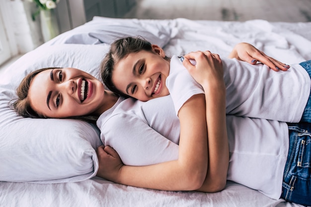 La atractiva hija y una madre tendida en la cama