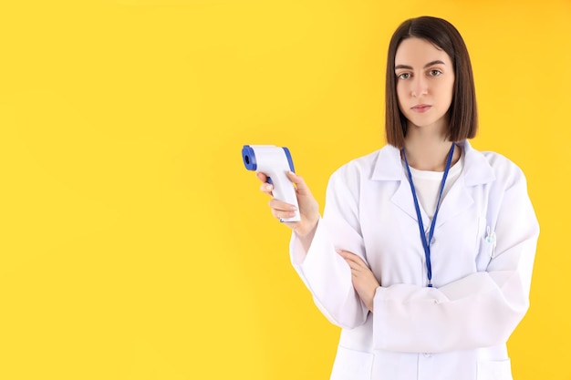 Atractiva joven doctora sobre fondo amarillo