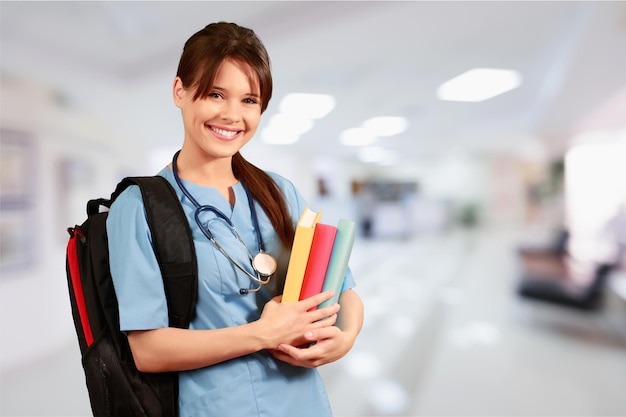 Atractiva joven estudiante de medicina con mochila y libros