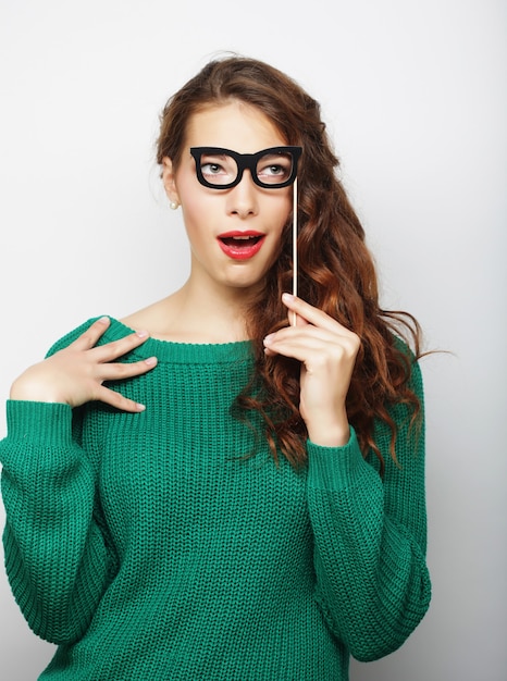 Atractiva joven juguetona con gafas postizas, lista para la fiesta