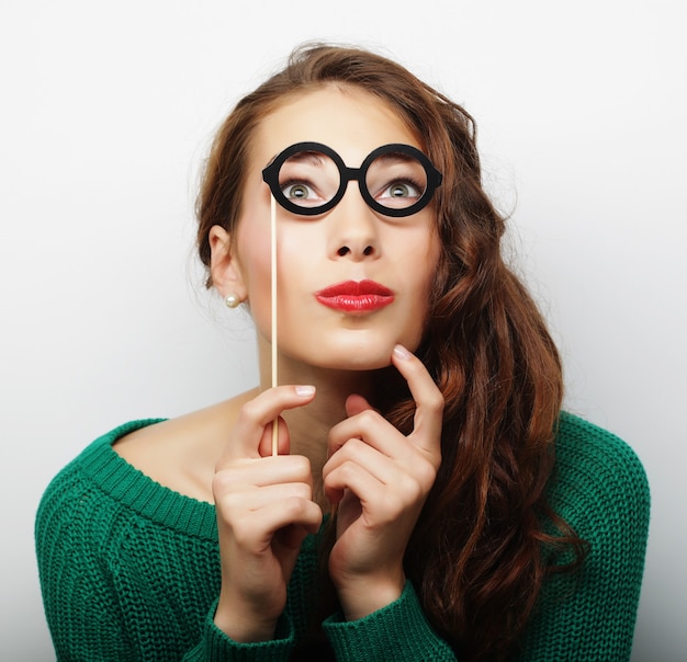 Atractiva joven juguetona con gafas postizas, lista para la fiesta