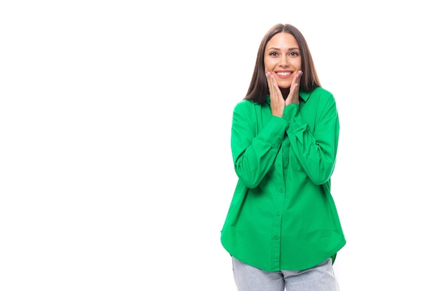 Atractiva joven modelo femenina de cabello castaño con ojos marrones en camisa verde aislada en blanco