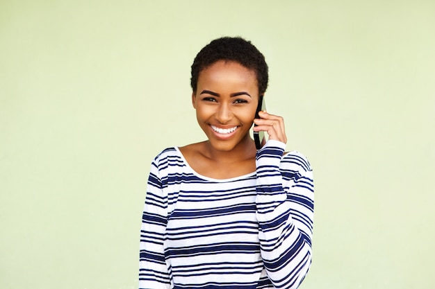 Atractiva joven mujer negra escuchando teléfono móvil