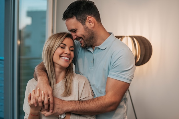 Atractiva joven pareja en el abrazo de amor.