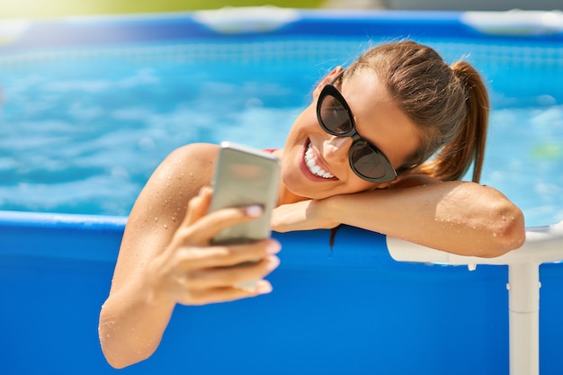 Foto una atractiva joven relajándose en la piscina en el patio trasero