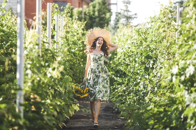 Atractiva joven rubia con ramo de girasoles. Concepto libre de alergias. Hembra con flores en verano.