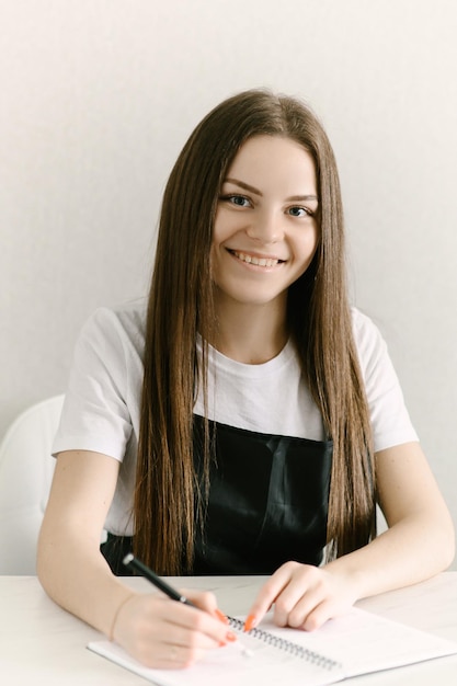 Atractiva joven rusa maestra de manicura profesionalmente hace manicura y esmalte de uñas salón de belleza retrato del maestro enfoque selectivo