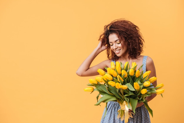 Atractiva mujer africana con ramo de flores