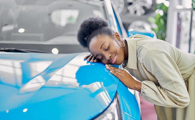 Atractiva mujer afro joven disfruta de ser propietario de un auto nuevo