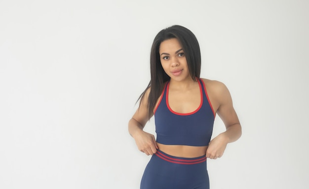 Atractiva mujer afroamericana negra con polainas de color y ropa de fitness superior