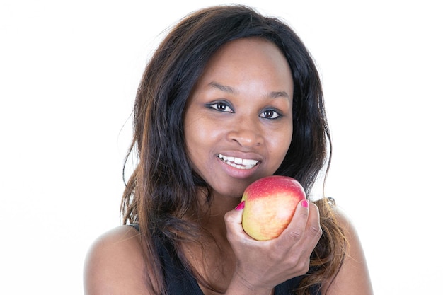 Atractiva mujer afroamericana sosteniendo comiendo manzana roja