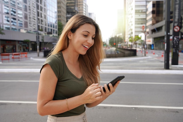 Atractiva mujer brasileña a través de teléfono móvil en la Avenida Paulista Sao Paulo Brasil