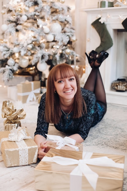 Atractiva mujer caucásica posa para una foto en un ambiente navideño en casa