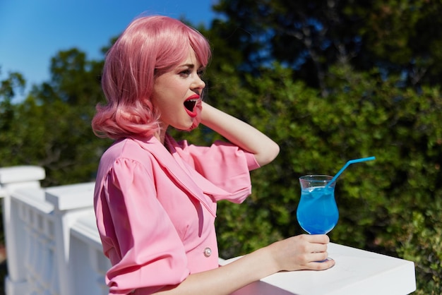 Atractiva mujer disfrutando de un colorido concepto de relajación en la terraza del hotel cóctel