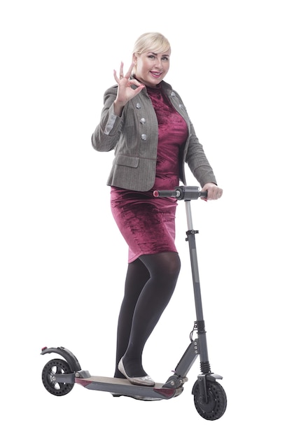 Atractiva mujer feliz con un scooter eléctrico aislado en un blanco