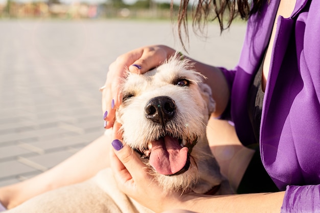 Atractiva mujer joven abrazando a su perro en el parque