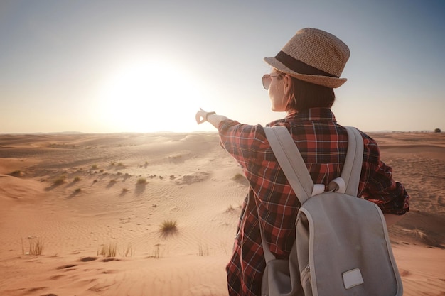 Atractiva mujer joven asiática en camisa a cuadros en el desierto