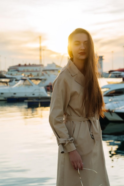 Atractiva mujer joven con cabello largo esperando su yate bajo el sol