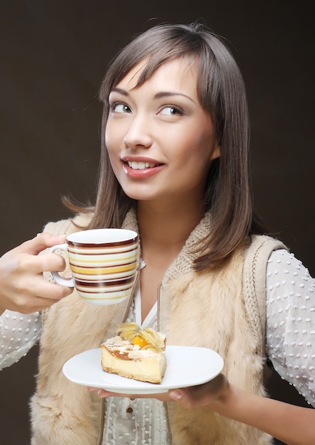 Atractiva mujer joven con café y postre