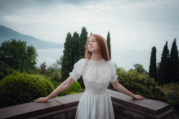 Atractiva mujer joven disfrutando de su tiempo al aire libre en el parque Hermoso palacio jugosas verduras después de una lluvia en la primavera