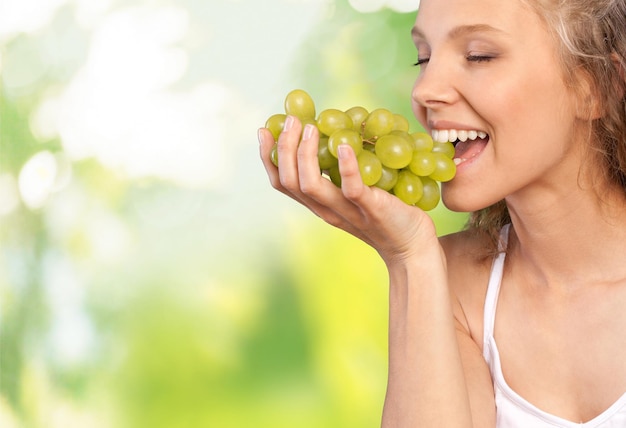 Atractiva mujer joven disfrutando de uva fresca