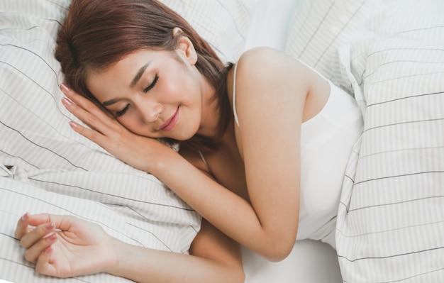 Foto atractiva mujer joven durmiendo en la cama