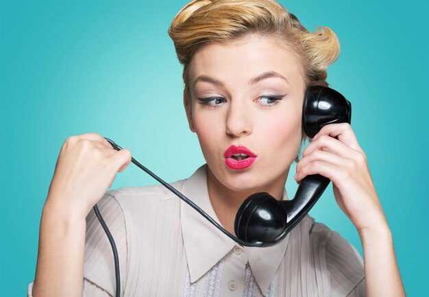 Atractiva mujer joven hablando por teléfono vintage