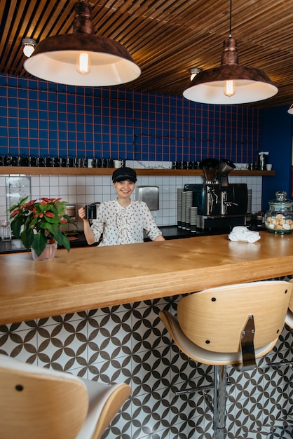 Foto atractiva mujer joven haciendo un café en una cafetería o cocina de oficina