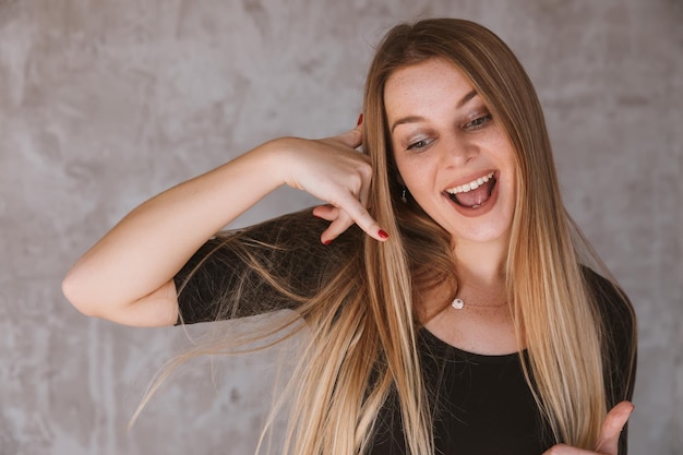 Foto atractiva mujer joven imita conversación telefónica mantiene h