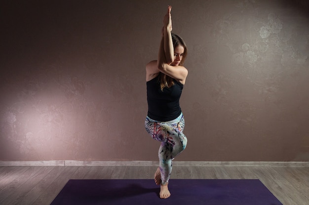 Atractiva mujer joven practicando yoga vistiendo ropa deportiva