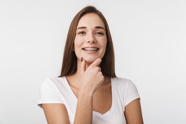 Atractiva mujer joven que se encuentran aisladas sobre la pared blanca, riendo