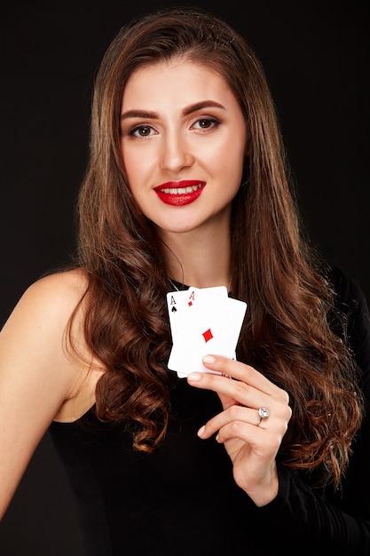 Atractiva mujer joven sosteniendo la combinación ganadora de cartas de póquer