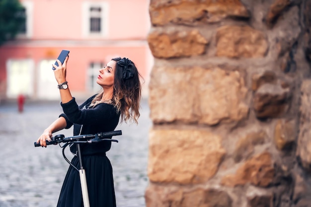 Atractiva mujer joven tomando selfie en las calles de la ciudad Retrato de mujer joven haciendo muecas a la cámara