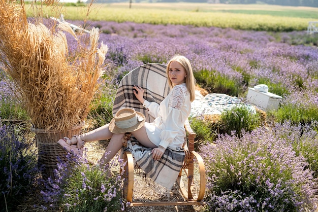 Atractiva mujer joven en vestido blanco posando en lavanda