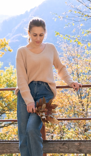 Atractiva mujer de mediana edad feliz en suéter tiene ramo de hojas coloridas temporada de otoño