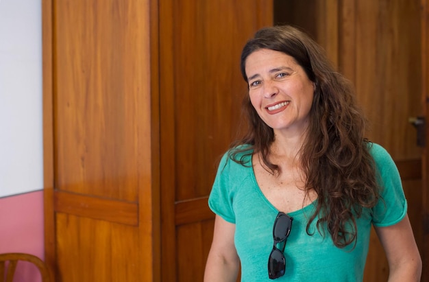 Atractiva mujer de mediana edad que parece sonriente en la casa