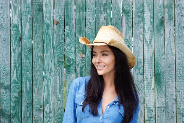 Atractiva mujer morena joven sonriendo con sombrero de vaquero