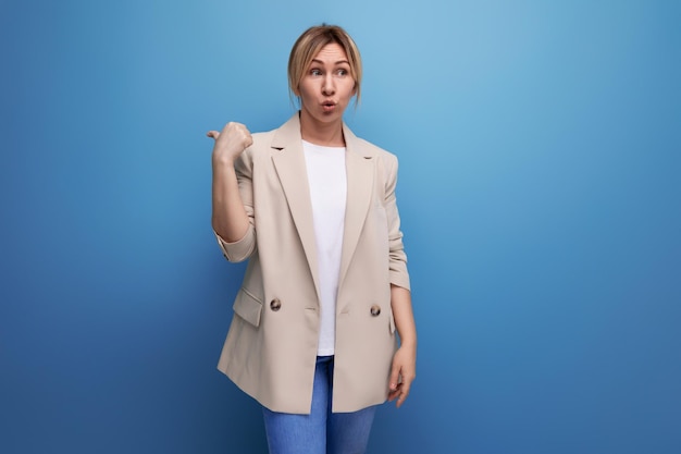 Atractiva mujer de negocios con una chaqueta beige muestra tener una idea con el dedo en un estudio