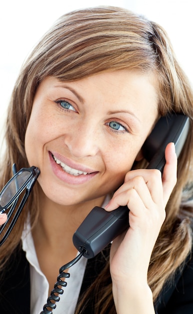 Atractiva mujer de negocios hablando por teléfono con gafas