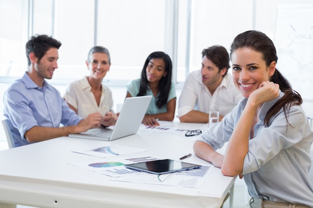 Atractiva mujer de negocios sonriendo en el lugar de trabajo