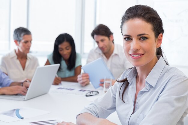 Atractiva mujer de negocios sonriendo en el lugar de trabajo