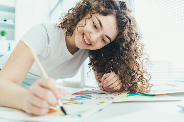 La atractiva mujer pintando un cuadro