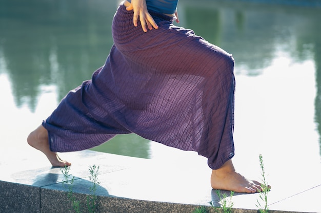 Atractiva mujer practicando yoga asana al aire libre