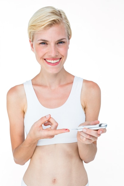 Atractiva mujer rubia haciendo prueba con monitor de glucosa en sangre