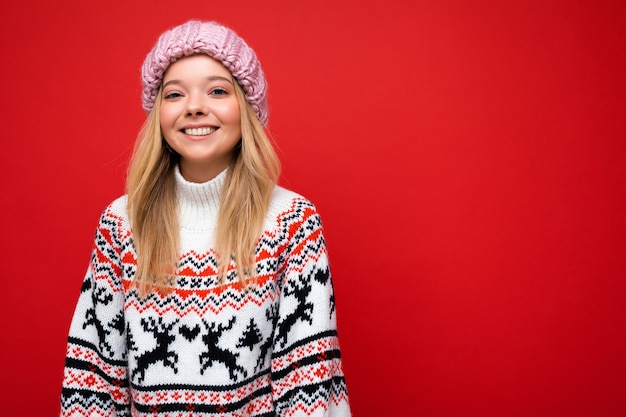 Atractiva mujer rubia joven feliz sonriente que se encuentran aisladas sobre fondo de colores vistiendo de pared